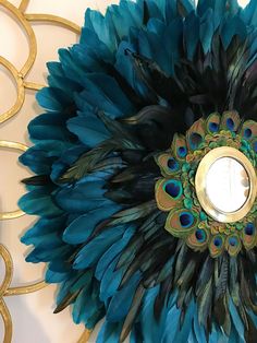 peacock feathers are arranged around a mirror on the wall