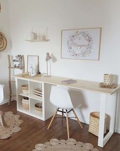 a white desk with two chairs and baskets on top of it in a living room