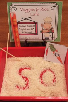 a red tray filled with rice next to a sign that reads 50 and two carrots