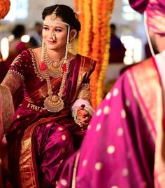 a woman in a red and gold outfit sitting down