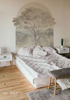 a large bed sitting in the middle of a bedroom next to a painting on the wall