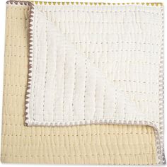 a close up of a blanket on top of a white table cloth with yellow trim