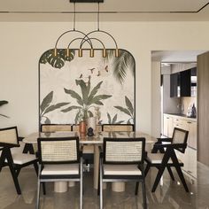 a dining room table with chairs and a plant on the wall behind it in front of a mirror