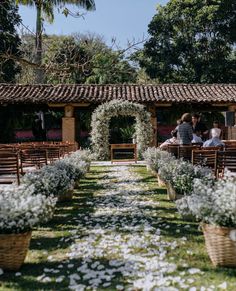 an outdoor ceremony with white flowers and greenery