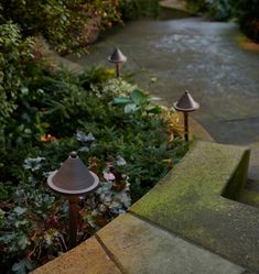 three lights on the side of a walkway