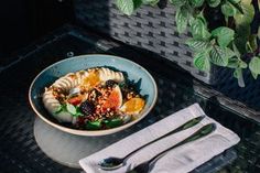 a bowl of food on a table with silverware