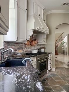 a kitchen with marble counter tops and white cabinets