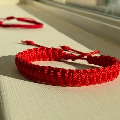 two red bracelets sitting on top of a window sill