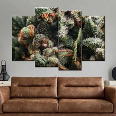 a brown couch sitting in front of a wall mounted painting