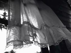 an old fashioned curtain is hanging from the side of a house