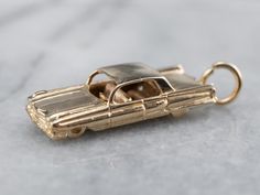 Road trip! This Cadillac-style vintage car charm is full of nostalgia. Spinning wheels and interior details make this pendant something special. This pendant does not come with the chain shown. Please feel free to contact us, we will help you find the perfect chain for your style and budget! Metal: 14K Yellow Gold Measures: 10 x 32 mm, with bail Marks: "14K" Stamped on the reverse Car Gold, Spinning Wheels, Retro Car, Cameo Ring, Spinning Wheel, Cute Charms, Car Charms, Retro Cars, Vintage Car