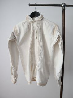 C1930s Transylvanian folk blouse. Acquired from my travels in the Carpathian Mountains.  Homespun linen. Really lovely pleated bib up the front. White glass buttons. Trapeze shape with balloon sleeves. Very small cutout or open weave sections around the collar, across the shoulders, cuffs and hem. The embroidery on these areas is in a peachy colour. Gathered pleats at the back of the neck, on the shoulders, base of the front panels and cuffs. Crochet trim at the hem. There are embroidered motif Folk Style Long Sleeve Linen Tops, Traditional Beige Cotton Blouse, Vintage Cotton Peasant Top For Daywear, Vintage Long Sleeve Blouse For Gatherings, Vintage Beige Linen Blouse, Traditional Fitted Blouse For Daywear, Traditional Cotton Blouse With Lace Trim, Fitted Traditional Blouse For Daywear, Victorian Long Sleeve Cotton Blouse