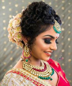 a woman in a bridal outfit with jewelry on her head and flowers in her hair