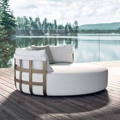 a white couch sitting on top of a wooden floor next to a body of water