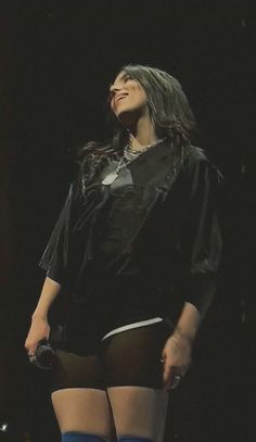 a woman in black shirt and blue stockings on stage