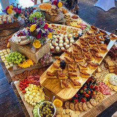 a table filled with lots of food on top of wooden trays next to each other