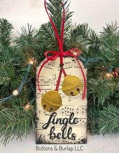 an ornament hanging from a christmas tree with music notes on it and red ribbon