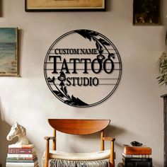 a tattoo studio sign mounted to the side of a wall next to a wooden chair