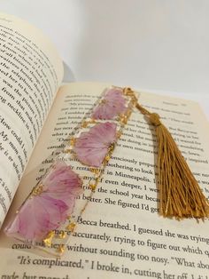 a tasseled bookmark sitting on top of an open book