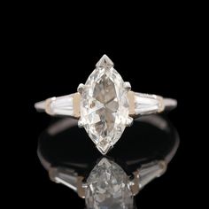 an old mine cut diamond ring with three baguets on the shoulders and side stones