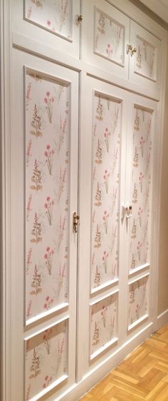 a white cabinet with floral wallpaper on it