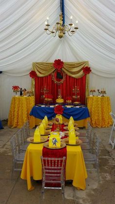 a table set up with yellow and red decorations