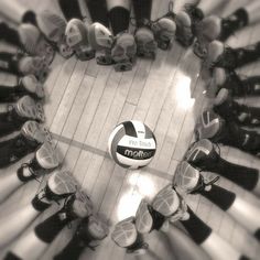 a group of people standing around a soccer ball in the middle of a circle with shoes on it