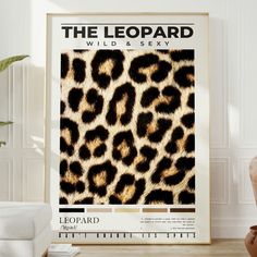 the leopard print is displayed in front of a white chair and vase with a potted plant