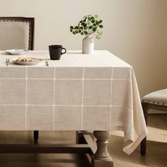 a table with a plate of food on it next to a chair and potted plant