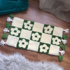 a green and white rug sitting on top of a wooden floor