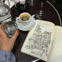 a person sitting at a table with an open book and coffee in front of them