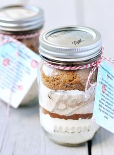 two mason jars filled with cookies on top of a table