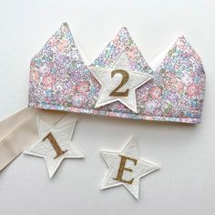 a crown, two stars and one number are on top of the headbands