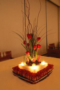 a square cake with candles and flowers on it