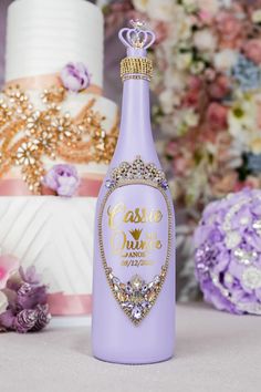 a purple bottle that is sitting next to some flowers and cake on a table with other cakes in the background