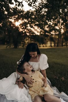 a woman holding a child on top of a blanket