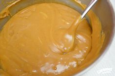 a metal mixing bowl filled with yellow batter