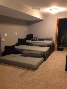 a group of beds sitting in the middle of a living room next to a doorway