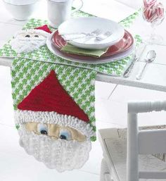 a santa clause table runner on top of a dining room table with plates and silverware