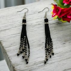 These fringe earrings in black and silver are the perfect blend of boho style and wearable art, featuring long tassels that make a bold statement. A thoughtful gift idea for your daughter, these neutral shade dangle earrings add a touch of fashion-forward elegance to any outfit. ABOUT * Beaded earrings * Fringe/ Tassel style * Measurements: -Height: approximately 4 inches -Width: approximately 1/2 inch  It is recommended that these earrings are stored laying flat or hanging up.  If you like this Adjustable Silver Tassel Earrings For Party, Bohemian Black Dangle Jewelry, Black Bohemian Dangle Jewelry, Bohemian Black Beaded Tassel Earrings Gift, Bohemian Tassel Earrings With Black Beads For Gift, Bohemian Black Tassel Earrings As Gift, Black Tassel Jewelry For Festival, Black Tassel Party Jewelry, Black Tassel Earrings With Dangling Beads As Gift