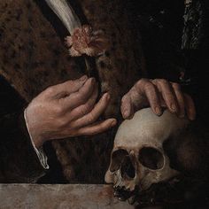 a close up of a person holding a skull with a flower in it's hand