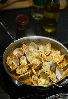 a pan filled with clams sitting on top of a stove