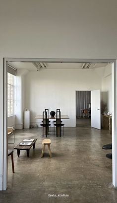 an empty room with tables and chairs in it's center, as seen from the doorway