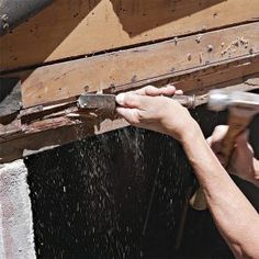 a person using a hammer to fix a wooden box with water coming out of it