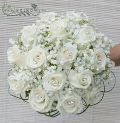 a bridal bouquet with white roses and baby's breath