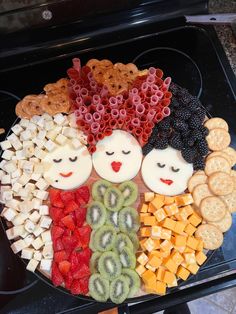 a platter filled with fruit, crackers and pretzels