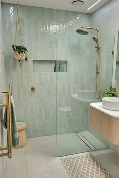 a bathroom with a walk in shower next to a sink and mirror on the wall