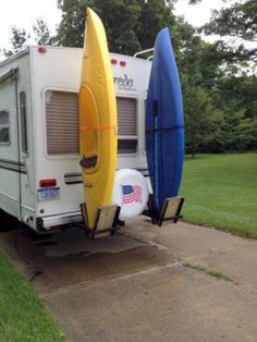 two surfboards are attached to the back of a camper