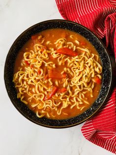 a bowl of soup with noodles and peppers