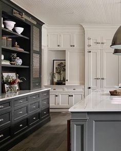 a large kitchen with white cabinets and an island